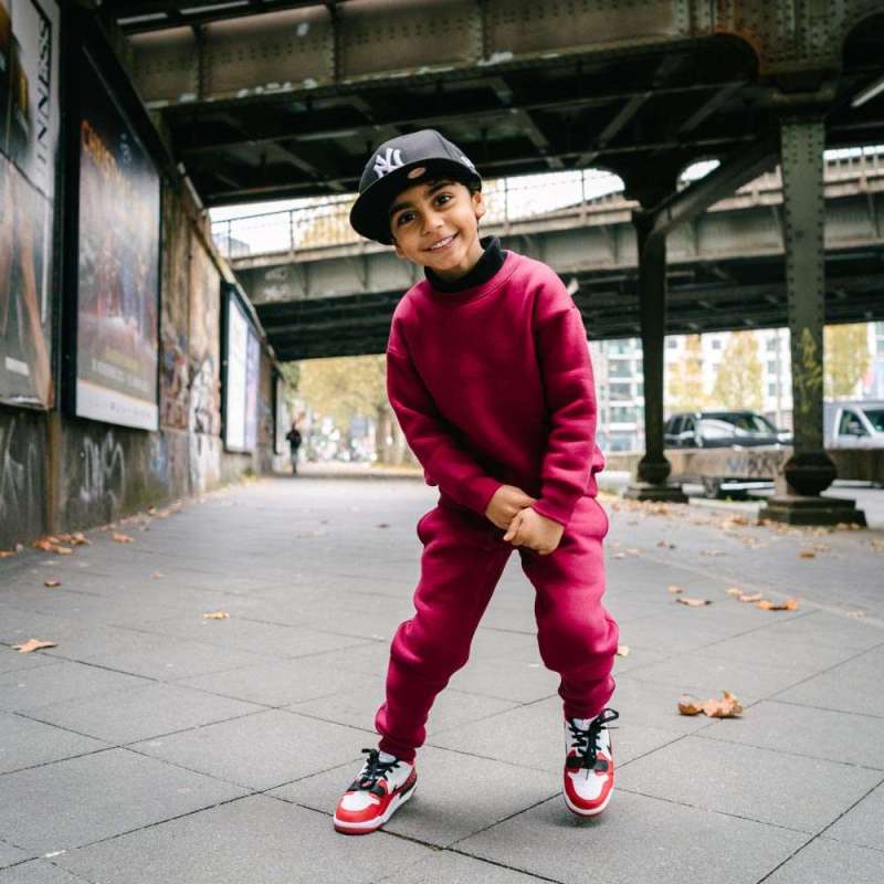 Children Urban Basic Jogginghose - Bordeaux Kind unter der Brücke lächelnd