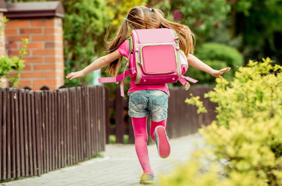 Mädchen mit Schulranzen rennt